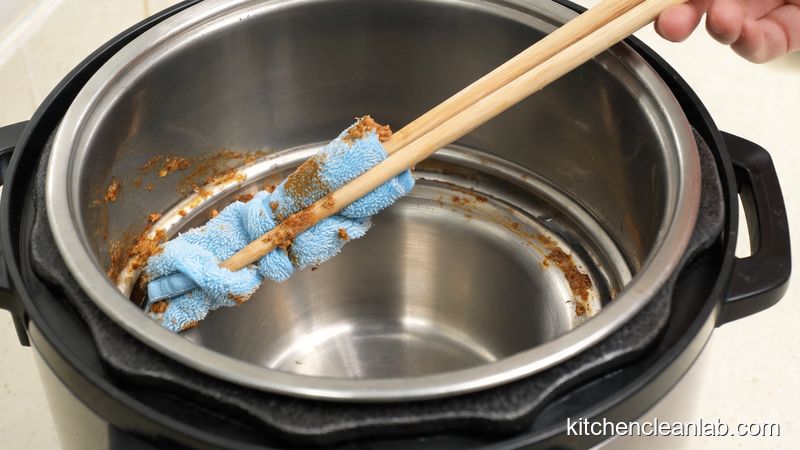 Microfiber cloth wrapped around chopstick cleaning Instant Pot rim groove